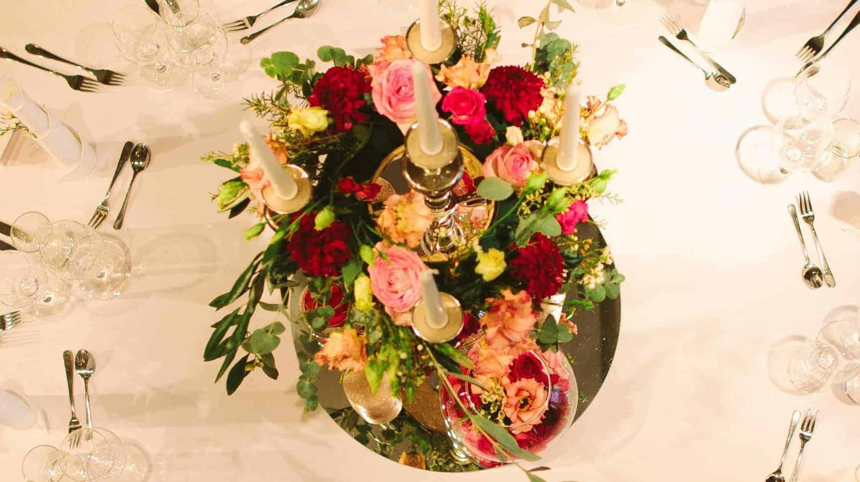 Bunter Blumenschmuck mit Rosen auf einem festlich gedeckten Tisch