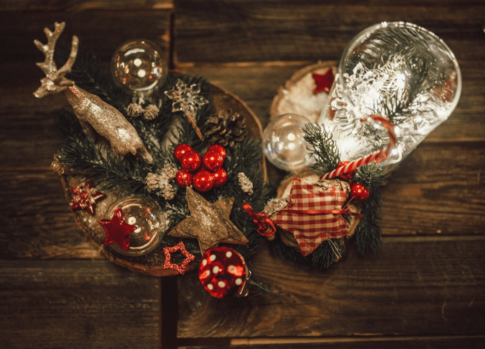 Dekorativer Hirsch mit roten Beeren und Christbaumkugeln auf dunkler Fläche