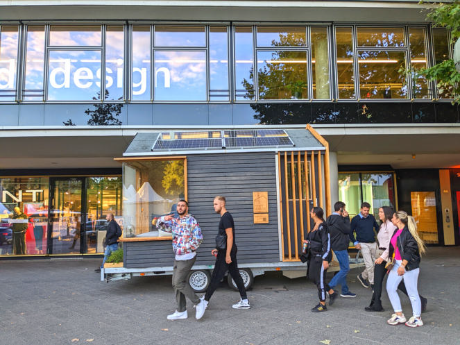 Mobiler Tiny Space vor einem Glasgebäude
