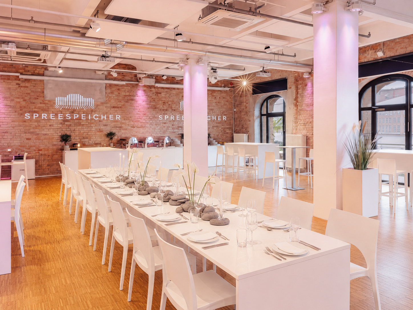 Weiße Festtafel mit Kerzen und Blumen im rosa beleuchteten Saal (KI-generierte Abbildung)