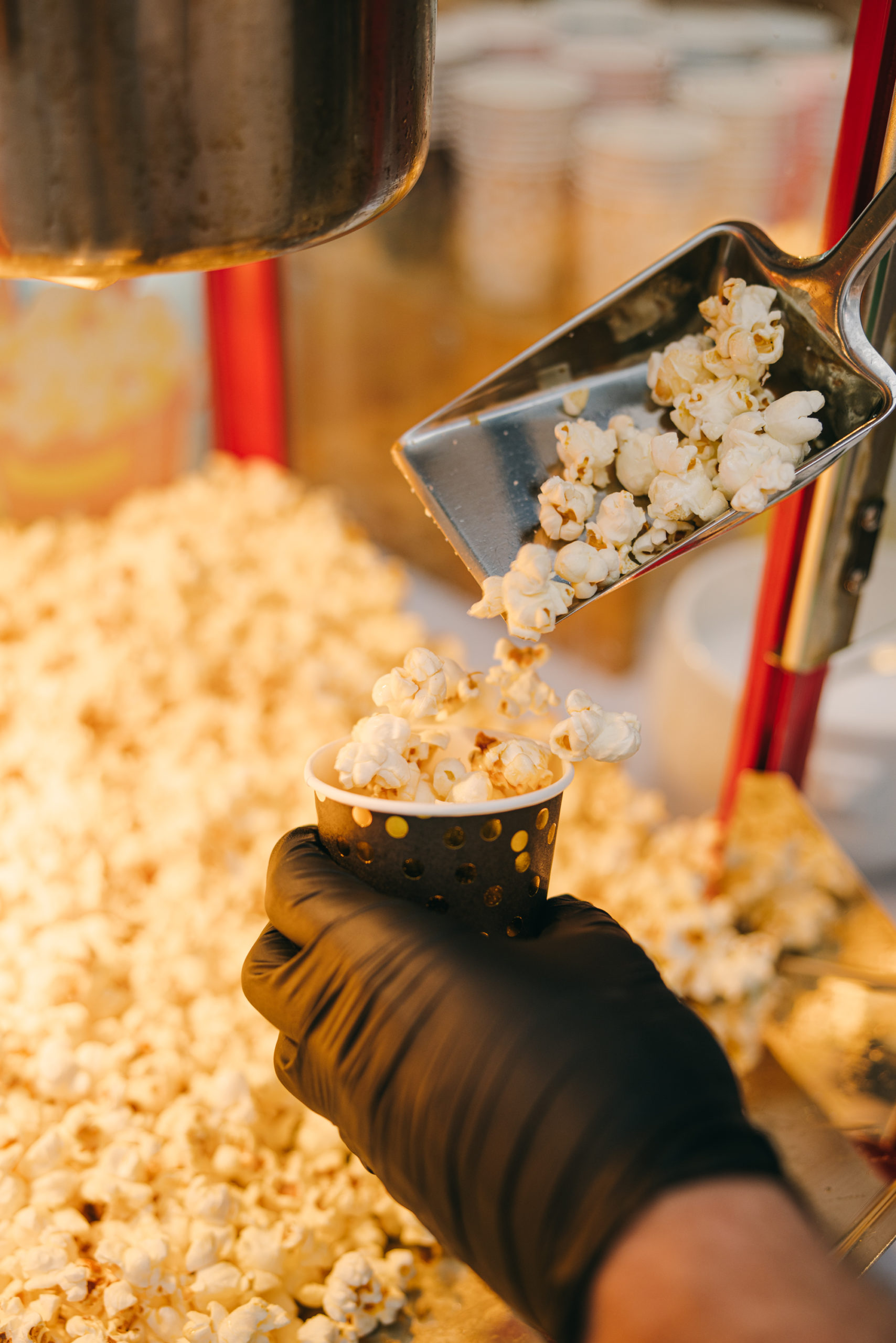 Popcorn wird mit der Schaufel in einen Becher gefüllt