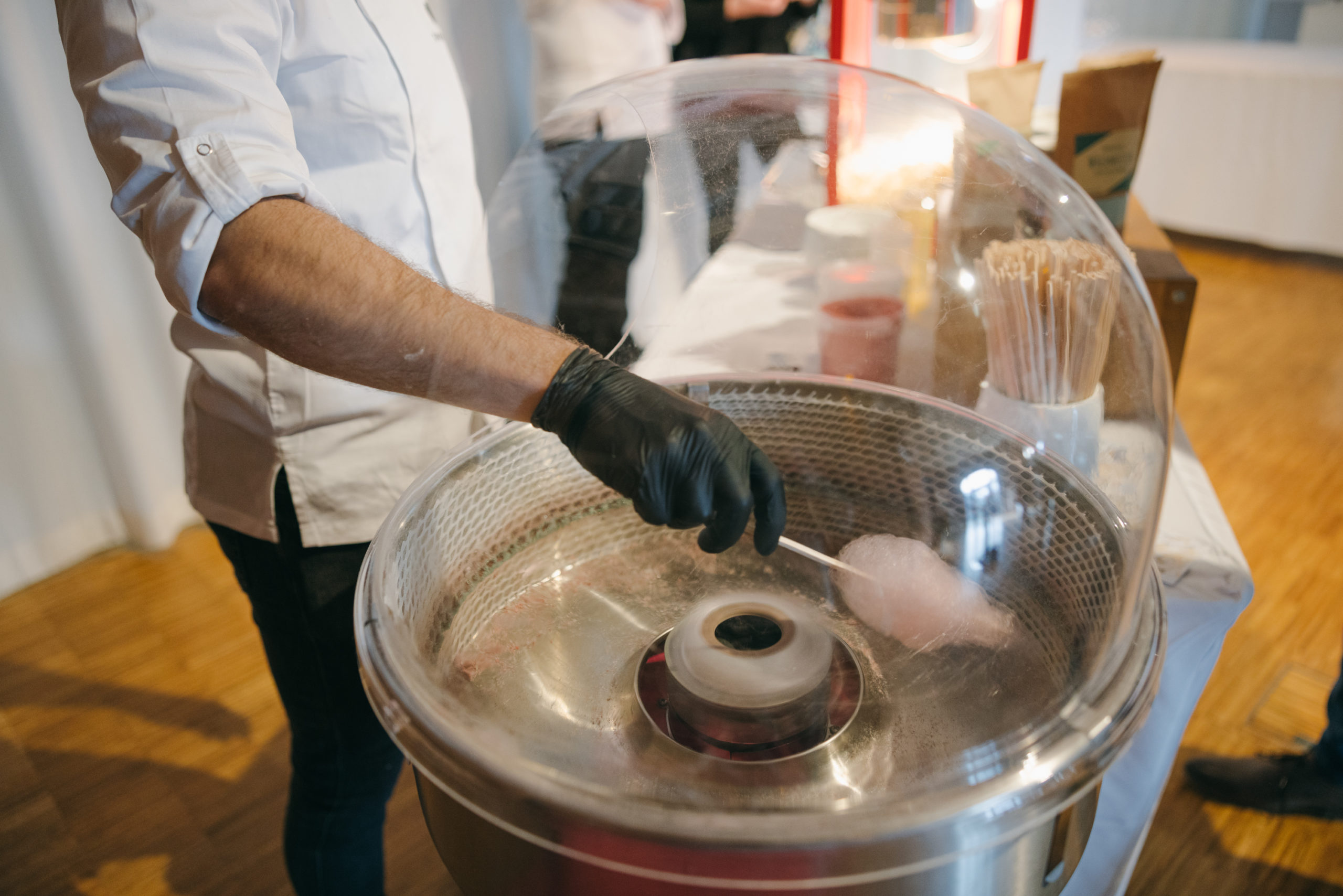 Koch dreht Zuckerwatte an der Zuckerwattemaschine