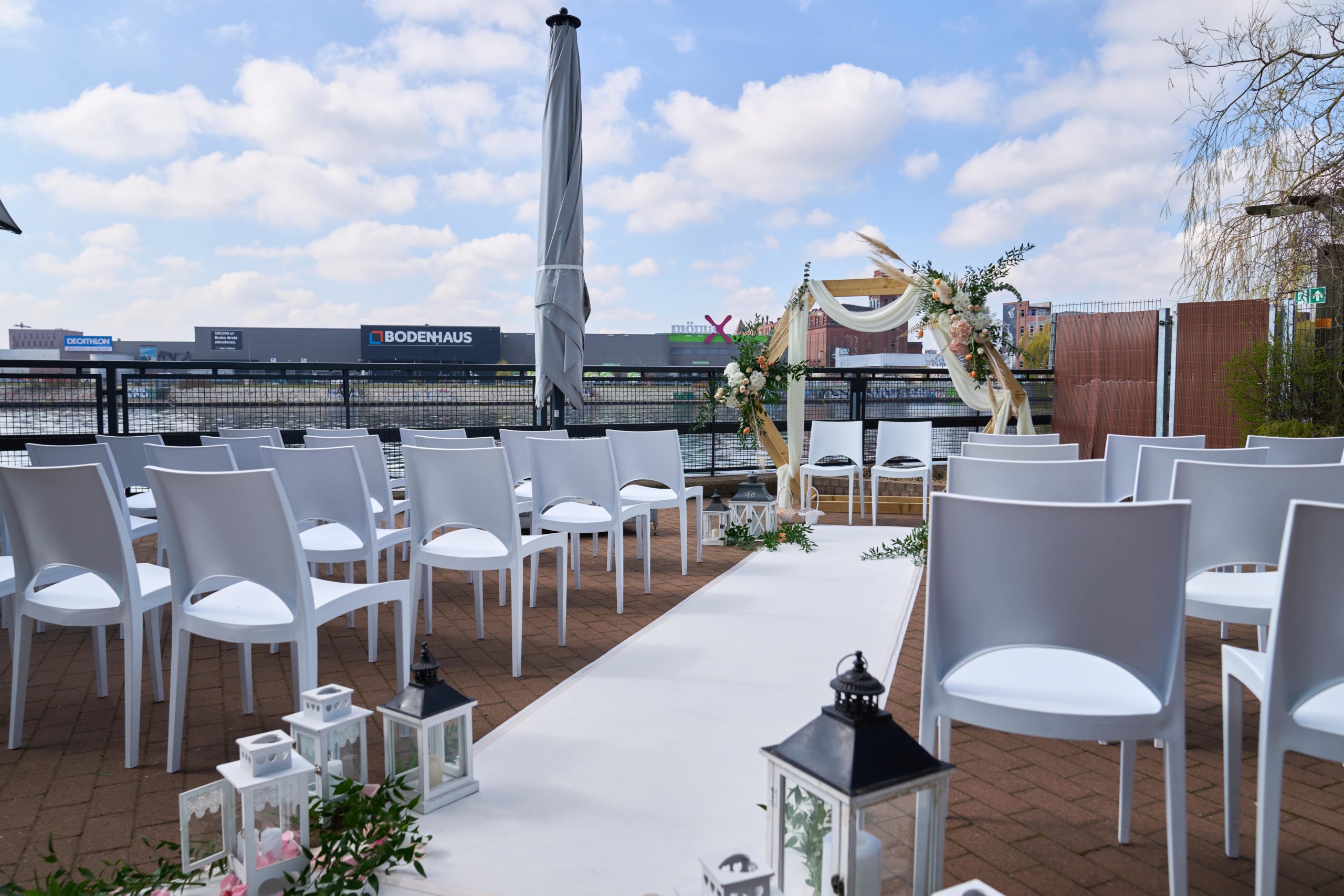 Freier Trauungsaufbau mit weißen Stühlen auf der Terrasse an der Spree