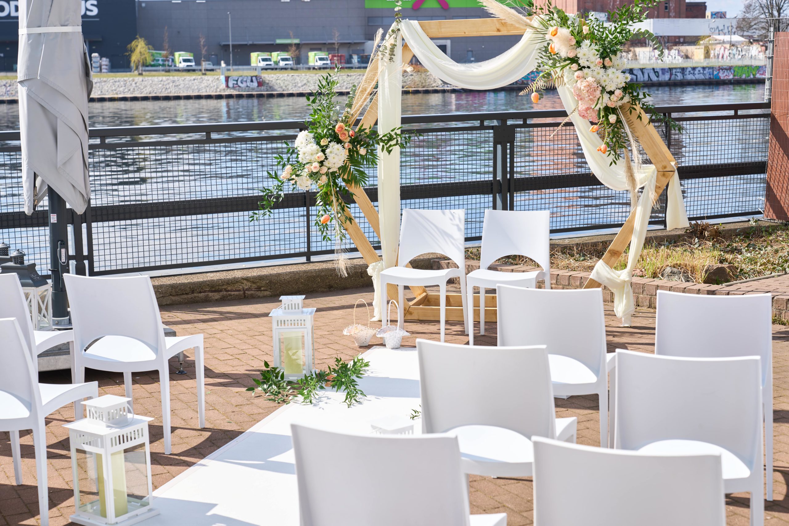 Blumengeschmückter Traubogen und Trautisch vor der Spree