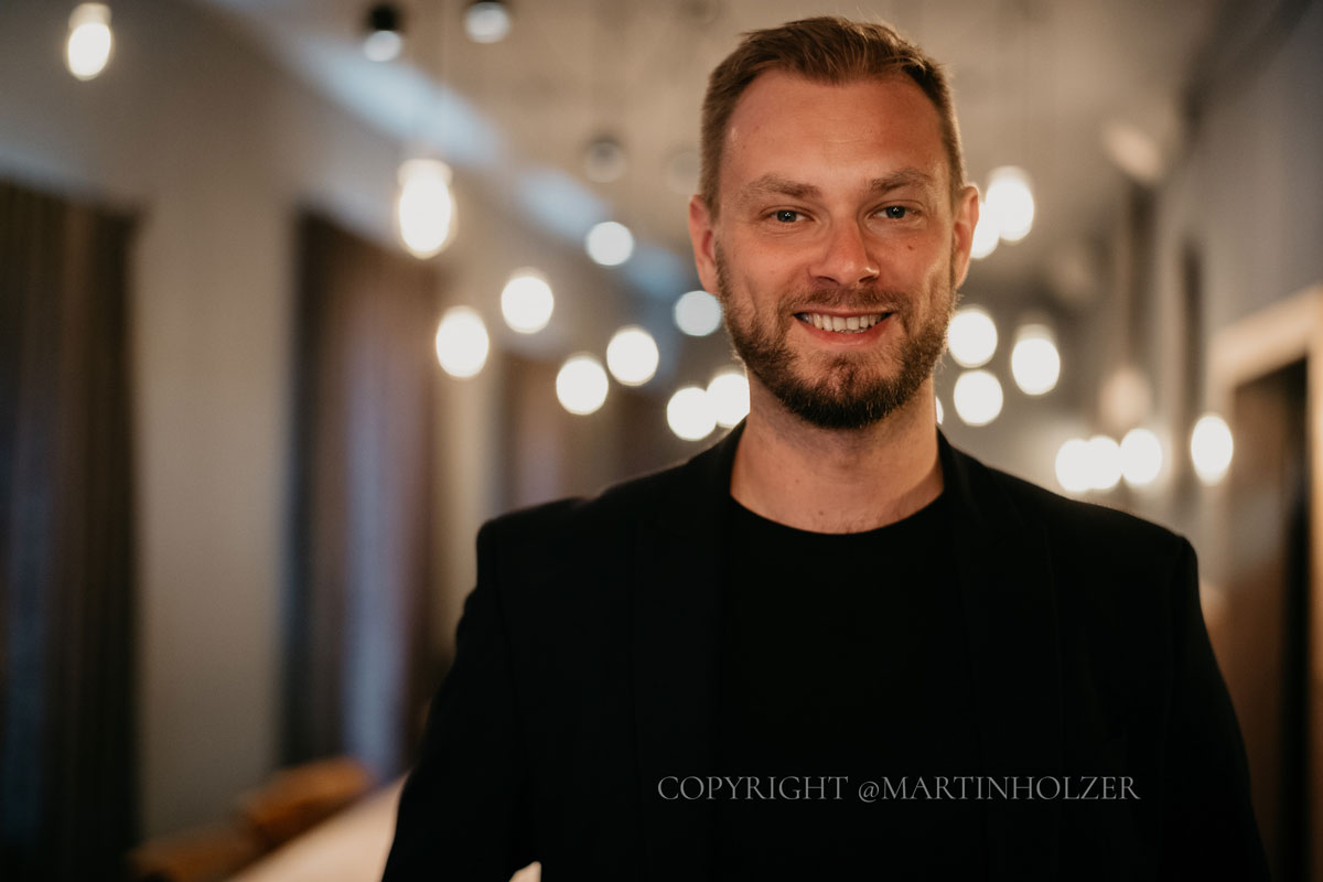 Impression von Dr. Johann-Jakob Wulf: porträt eines lächelnden Mannes in einem dunklen Shirt